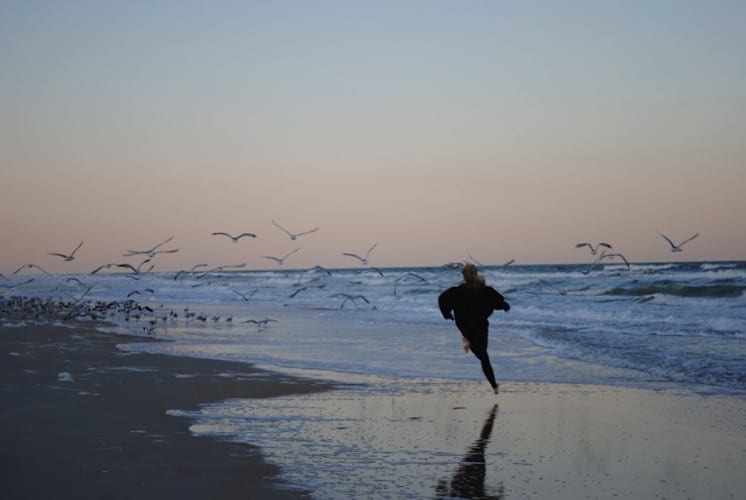 teenage girl running on beach