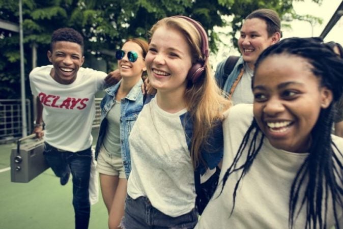 Teens wearing white T shirts laughing and hanging out