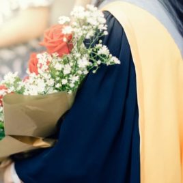 Female graduate holding roses