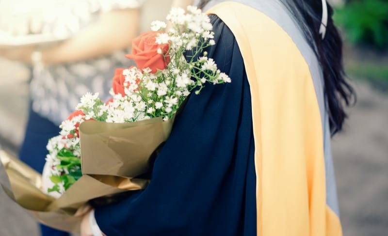 Female graduate holding roses