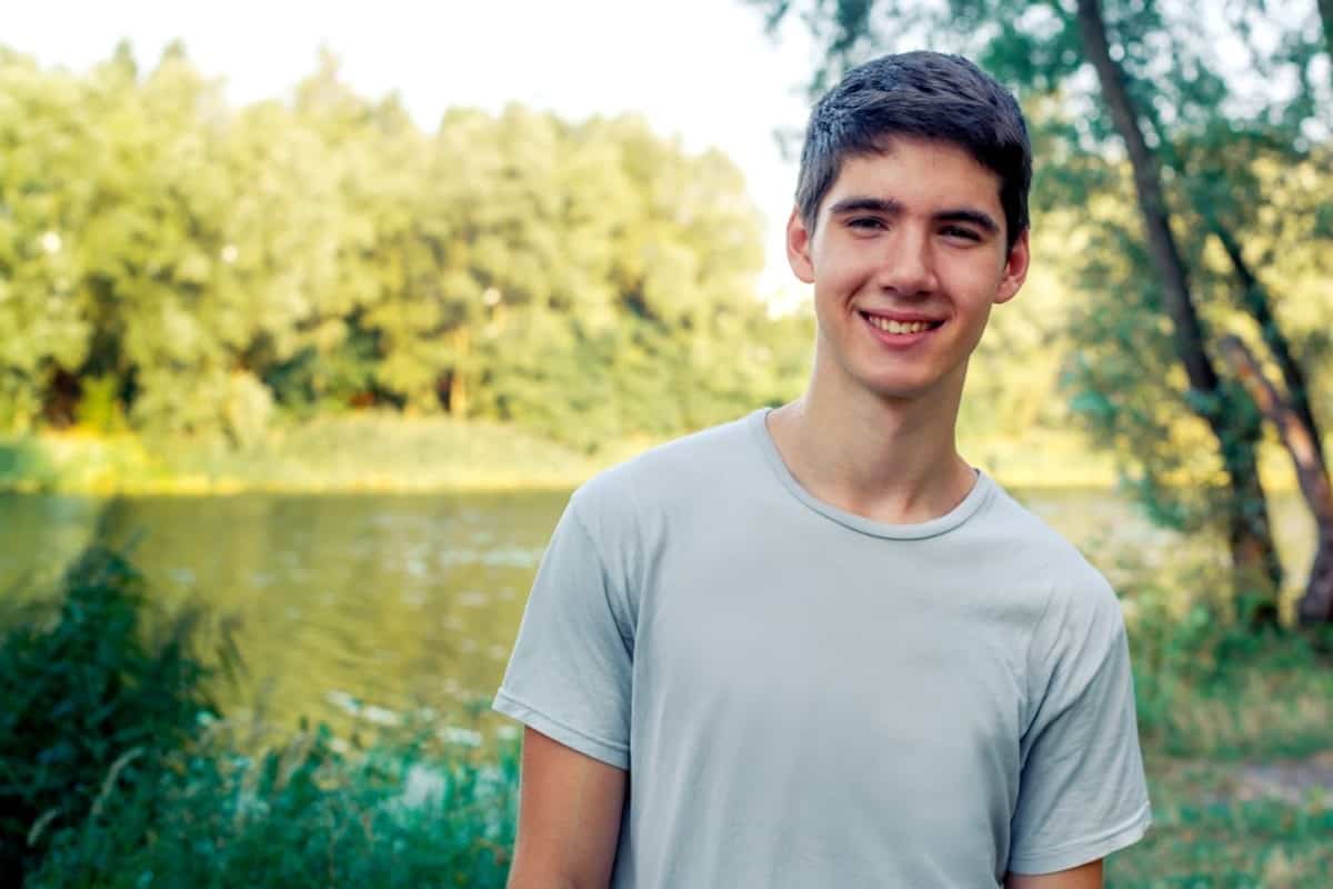 teenage boy by a lake 