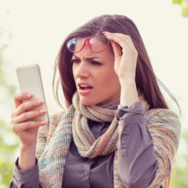 woman looking at cell phone shocked