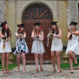 Female college graduates celebrate with champagne
