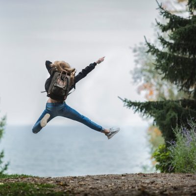 girl wearing backpack jumping