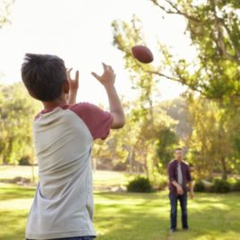 Boy throwing football to his father