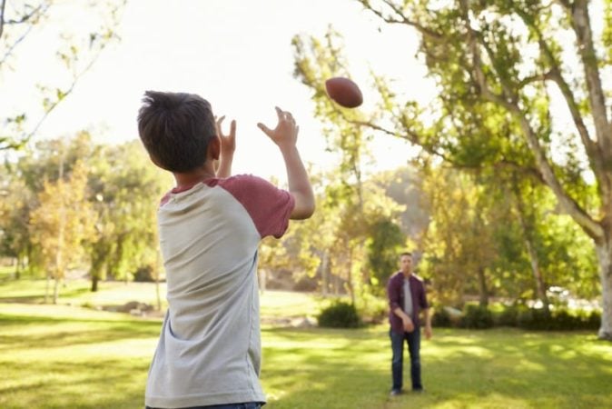 Boy throwing football to his father 