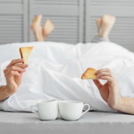 Couple in bed with toast and coffee after having sex