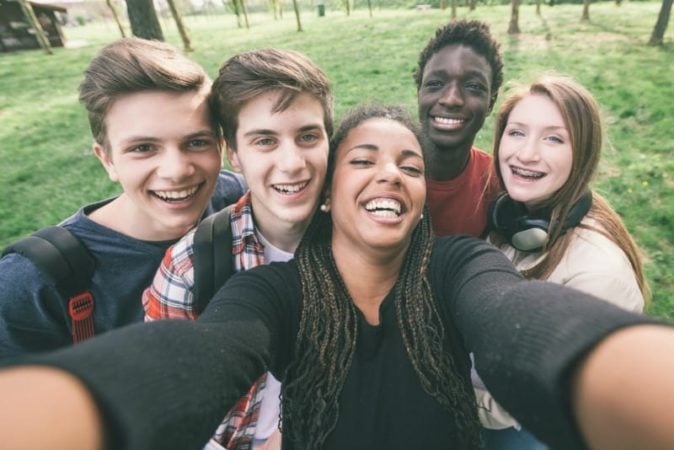 Multiracial high school freshman taking selfie