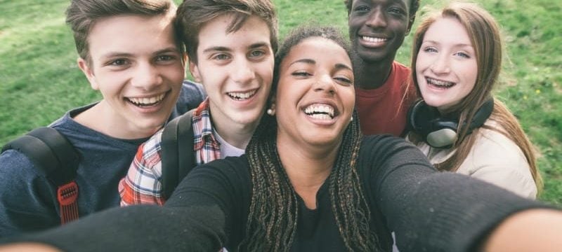 Multiracial high school freshman taking selfie