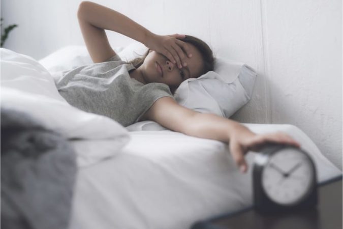 Teen waking up to an alarm clock 