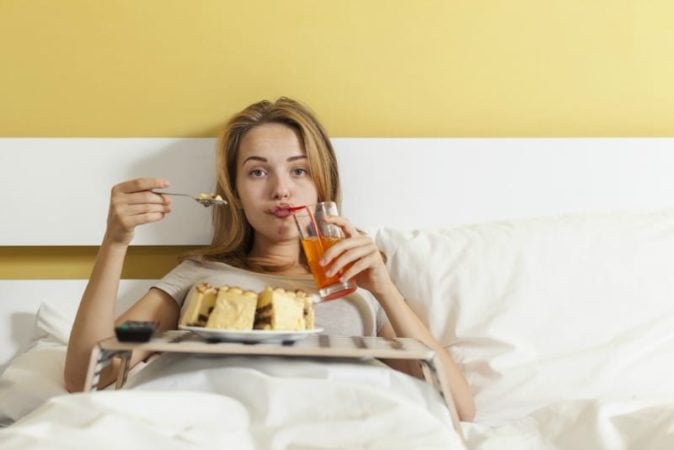 teen in bed eating cake 