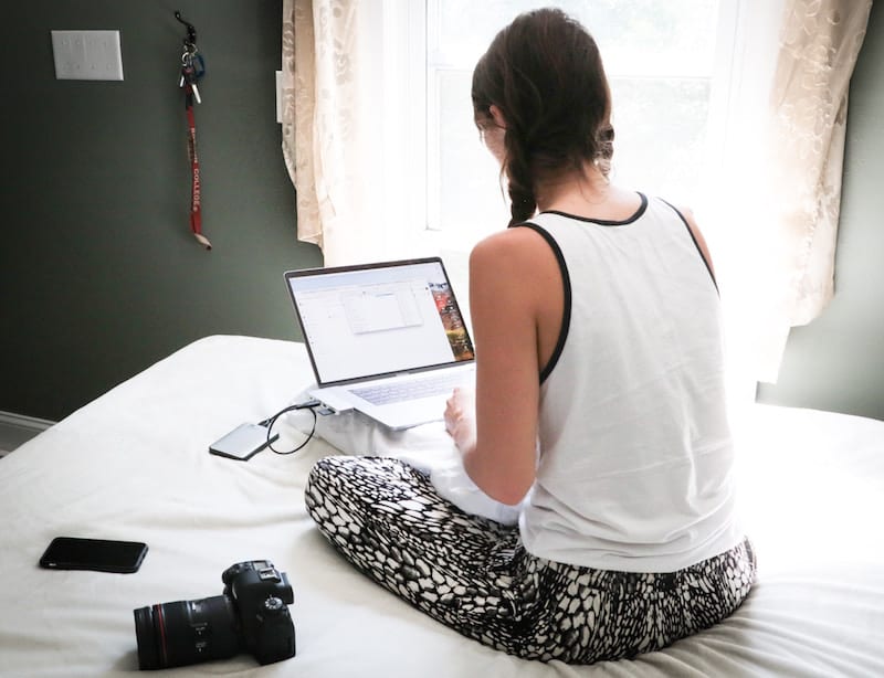 teen on computer in bed 