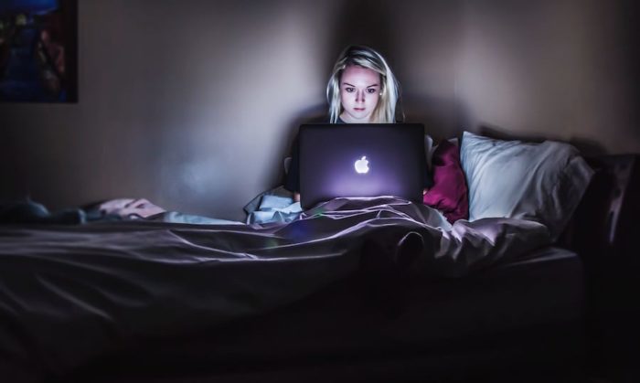 teen in bed with laptop 