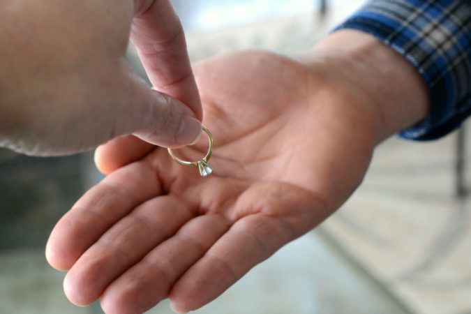 woman giving ring back to husband 