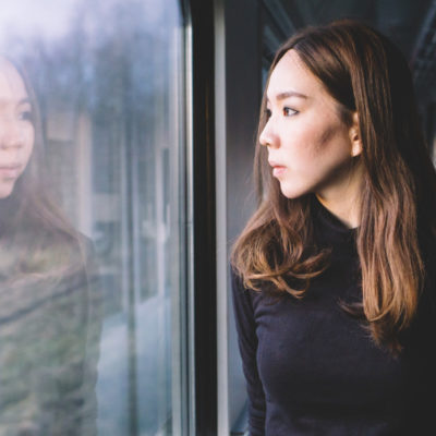 woman looking out the window of a train