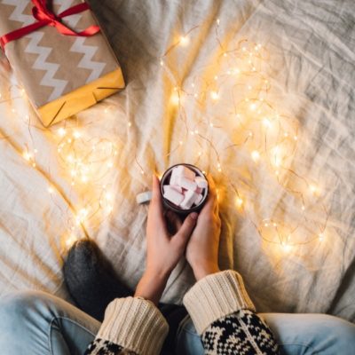 teen on bed with hot chocolate