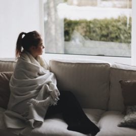teen in blanket on couch
