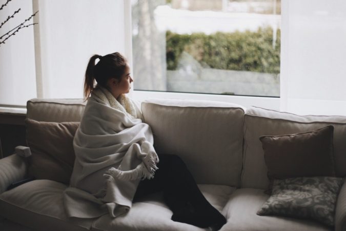 teen in blanket on couch