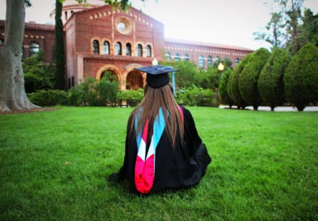 graduate sitting on quad