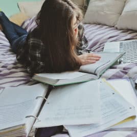 teen studying on her bed