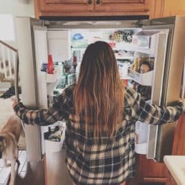 teen girl looking into fridge