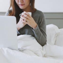 young woman in bed with coffee