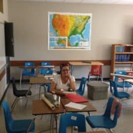 teacher in empty classroom