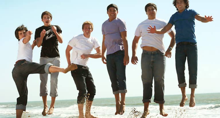 teen boys jumping in surf