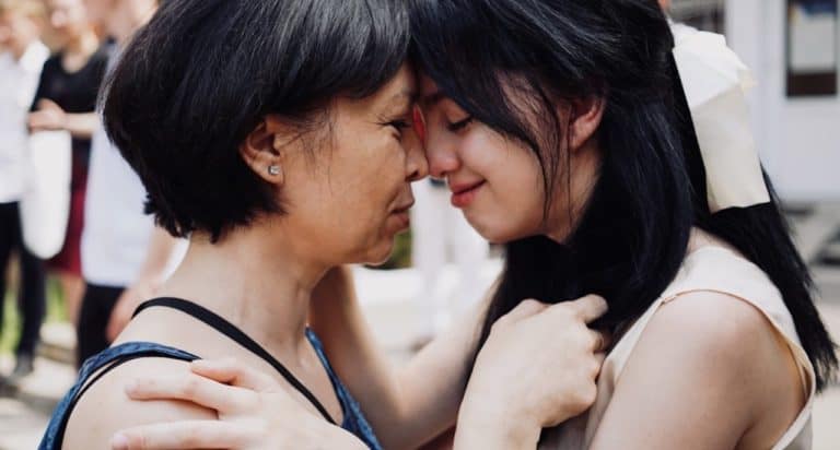 mom and teen daughter hugging