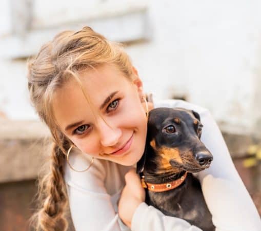 teen girl hugging dog