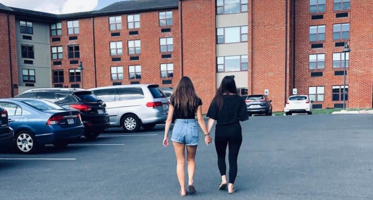 two daughters walking into college dorm