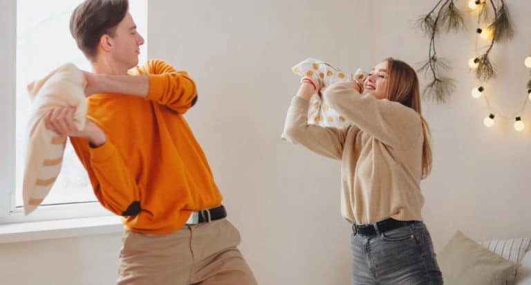 boy with orange shirt pillow fight