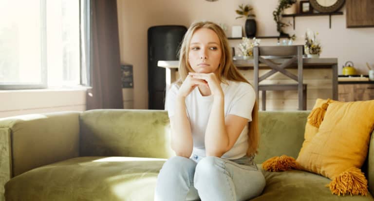 young sad woman on couch