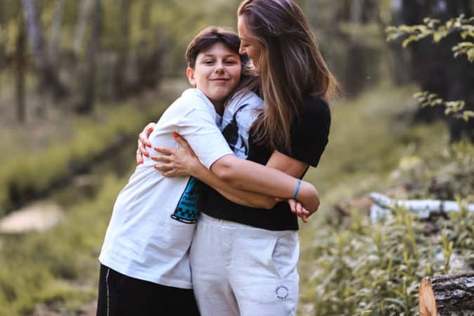 mom and teen boy hugging 