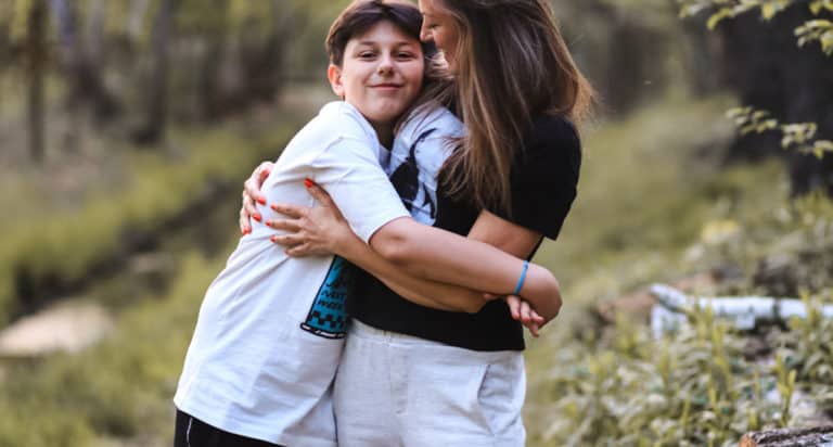 mom and teen boy hugging