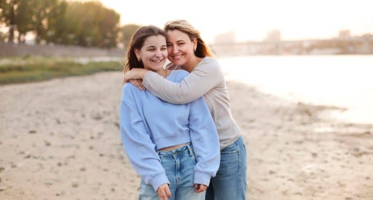 mom hugging teen daughter