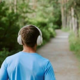 young man walking away wearing headphones