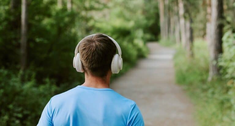 young man walking away wearing headphones